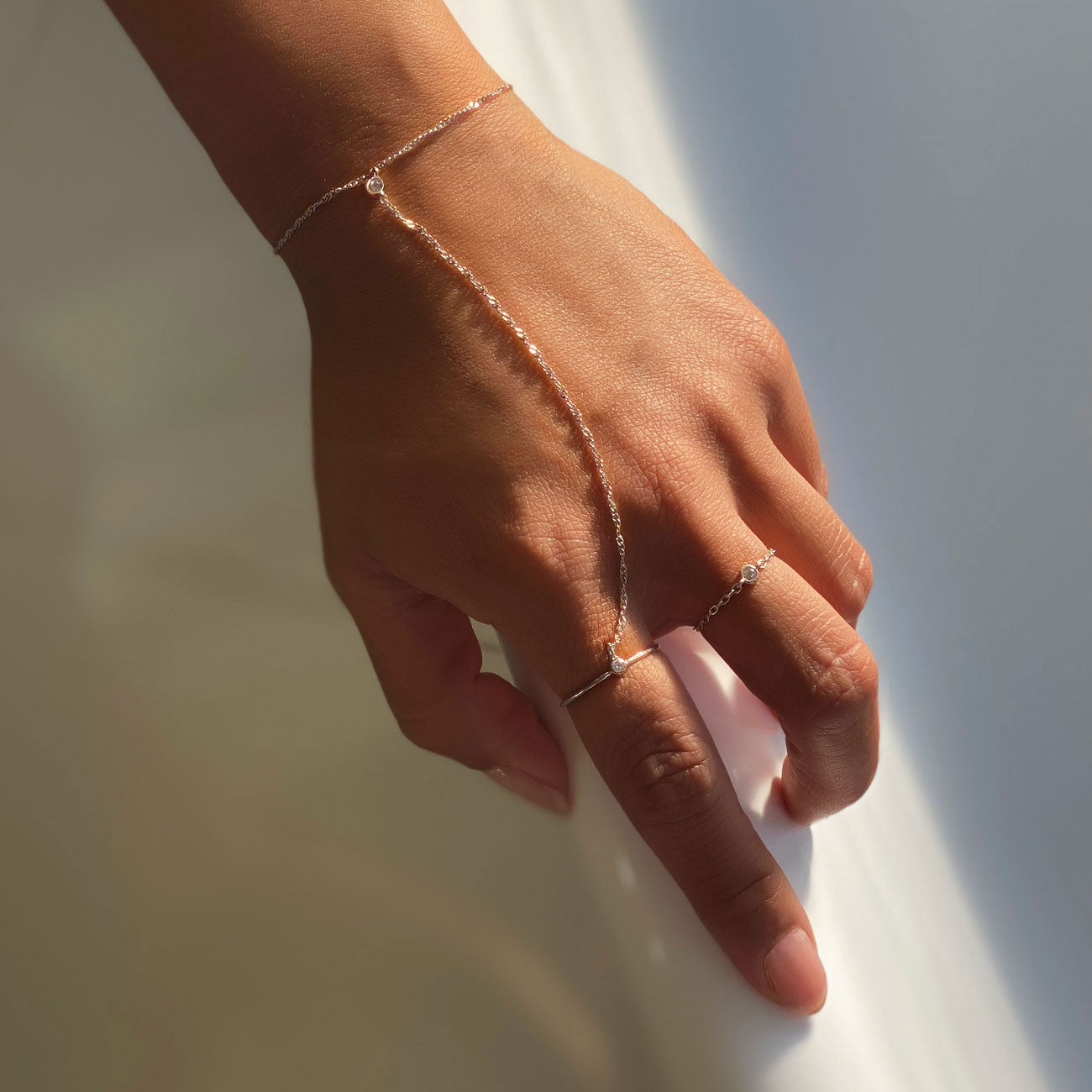 Hand wearing Sterling Silver Minimal Ring Handchain paired with Solitaire Chain Ring