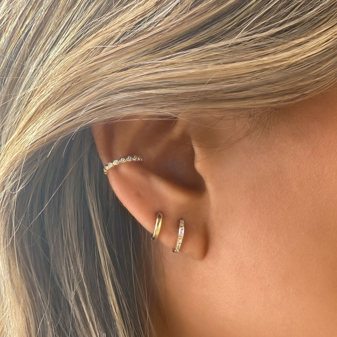 Gold huggie earrings paired with pave conch ear cuff