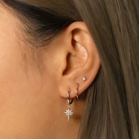 Silver Star Dangle Huggie paired with tiny silver hoop earrings and tiny crystal stud