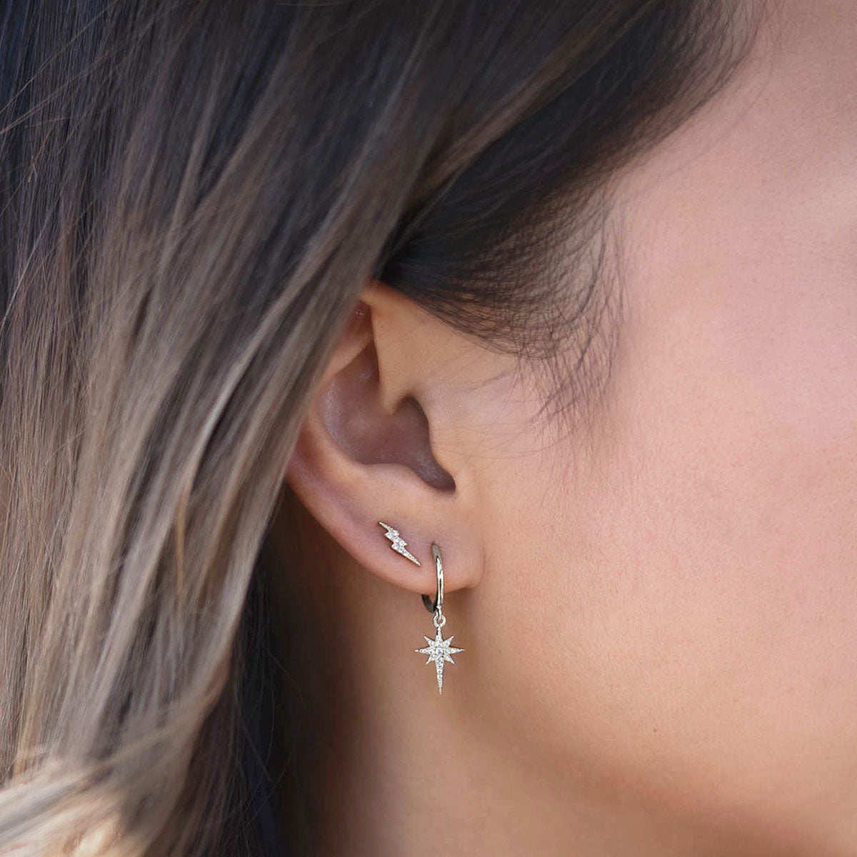 Sterling Silver Starburst Huggie Earrings paired with tiny Lightning Bolt Studs