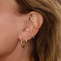 Ear Stack made of hoops, huggies, suspender earrings, and classic gold ear cuff