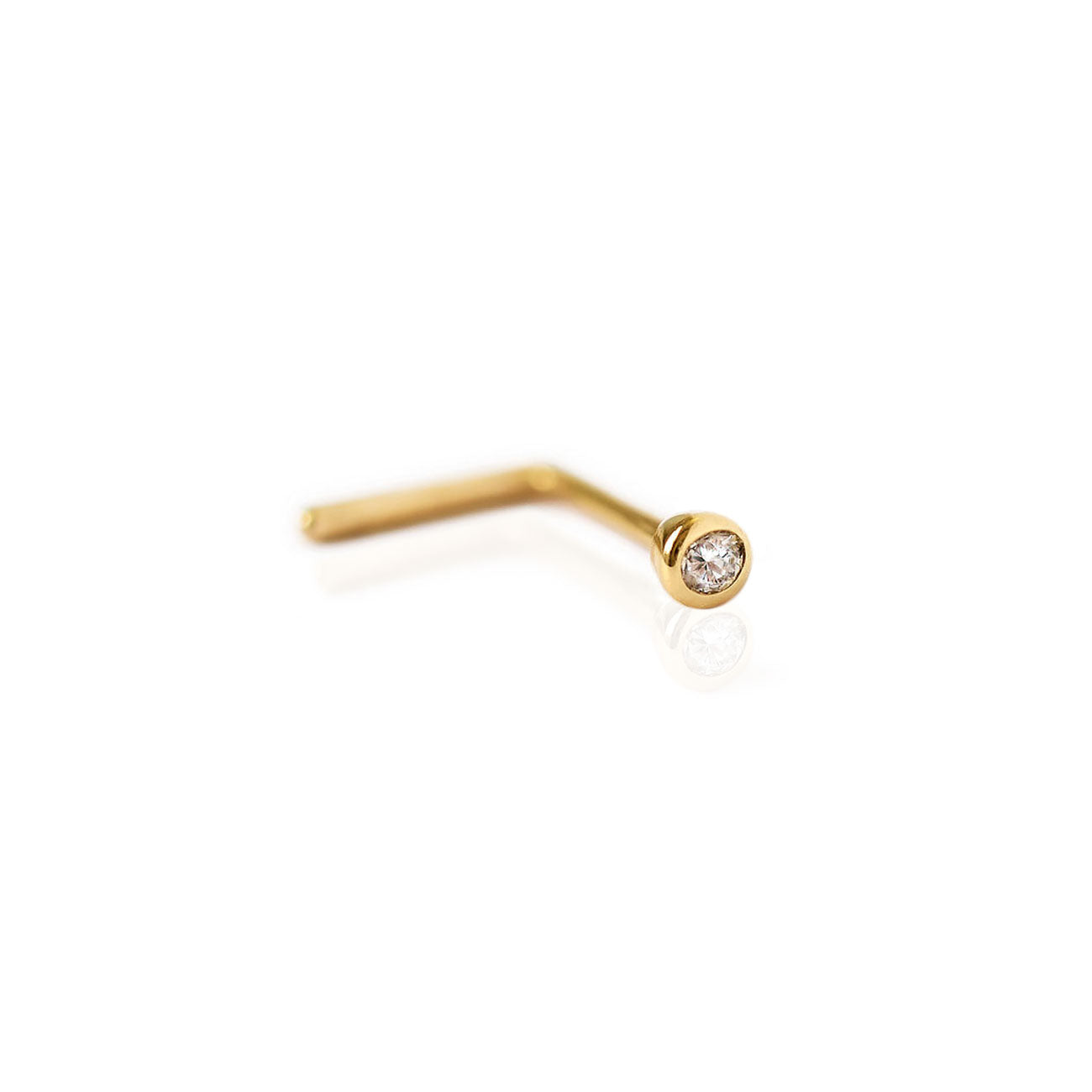 Gold L-shaped nose stud with a small round clear stone in a bezel, on a white background